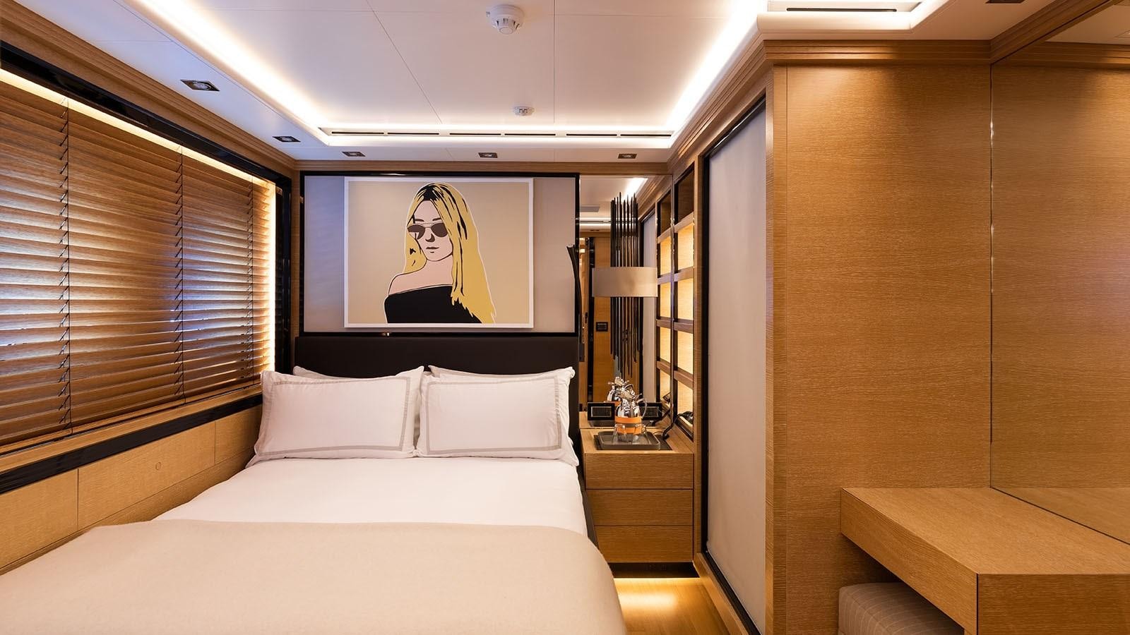 a room with a bed and a painting on the wall aboard ALASKA Yacht for Sale