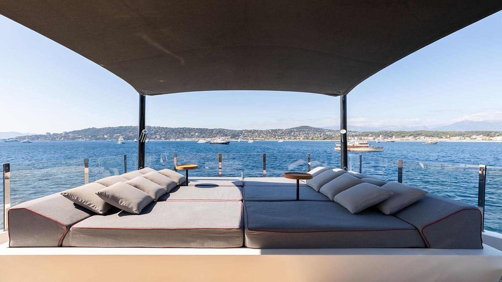 a bed with a view of the ocean and mountains in the background aboard ALASKA Yacht for Sale