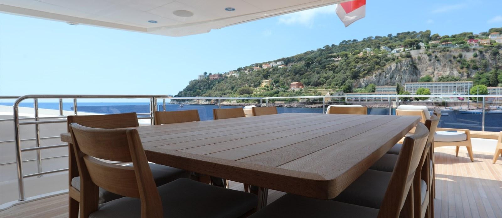 a table on a deck overlooking a large body of water aboard ALADDIN Yacht for Sale