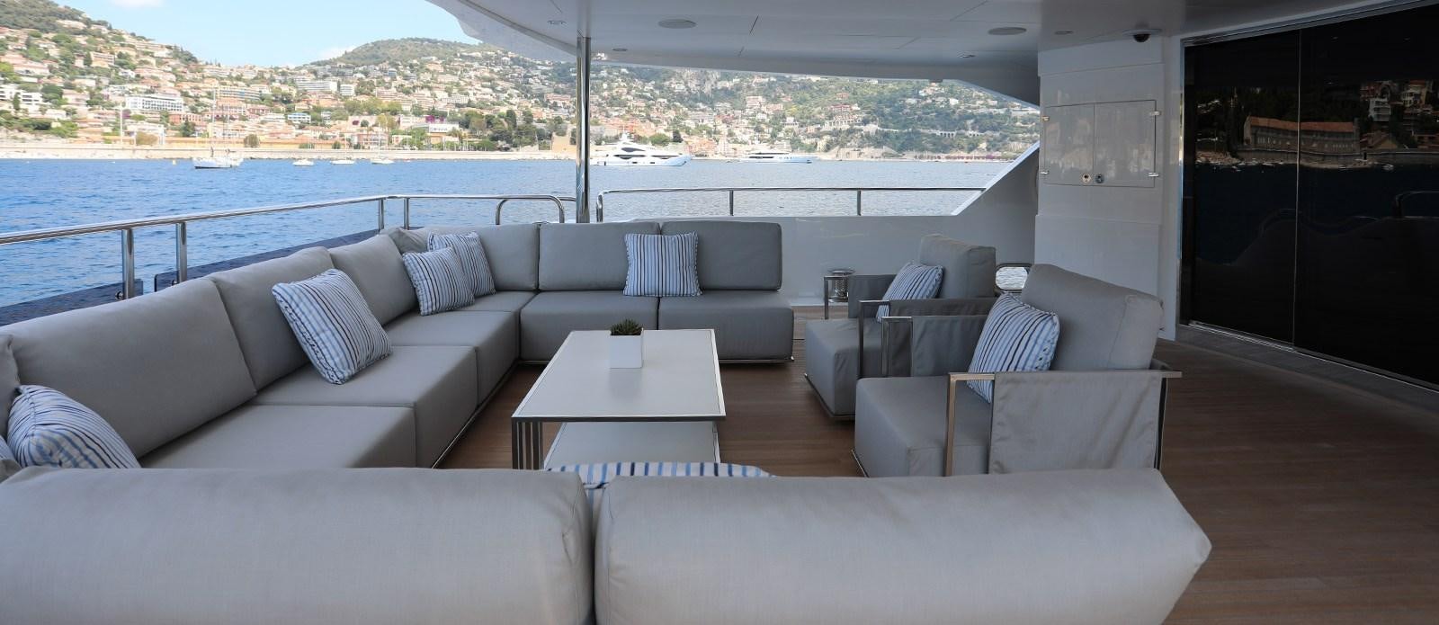 a couch and a table in a room with a view of a city aboard ALADDIN Yacht for Sale