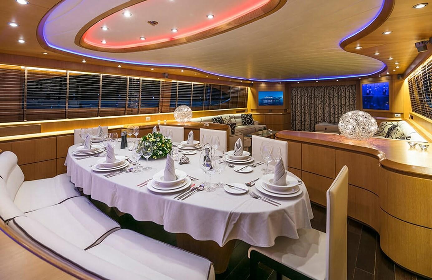 a room with tables and chairs aboard MAIORA 35 DP Yacht for Sale