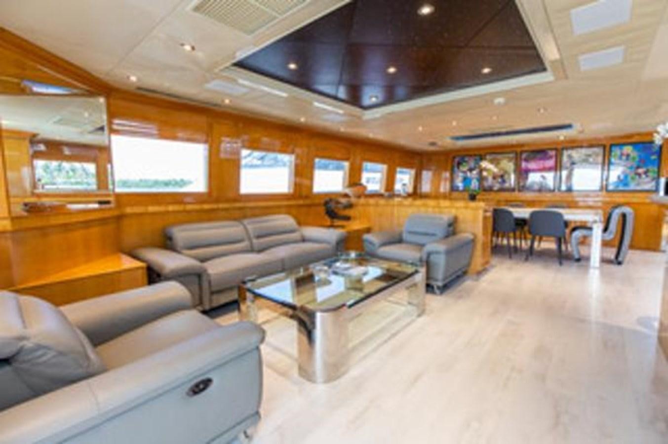 a room with a couch and a table and chairs aboard 2000 116 BAGLIETTO Yacht for Sale