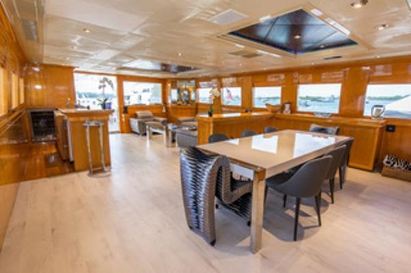 a large room with a table and chairs aboard 2000 116 BAGLIETTO Yacht for Sale