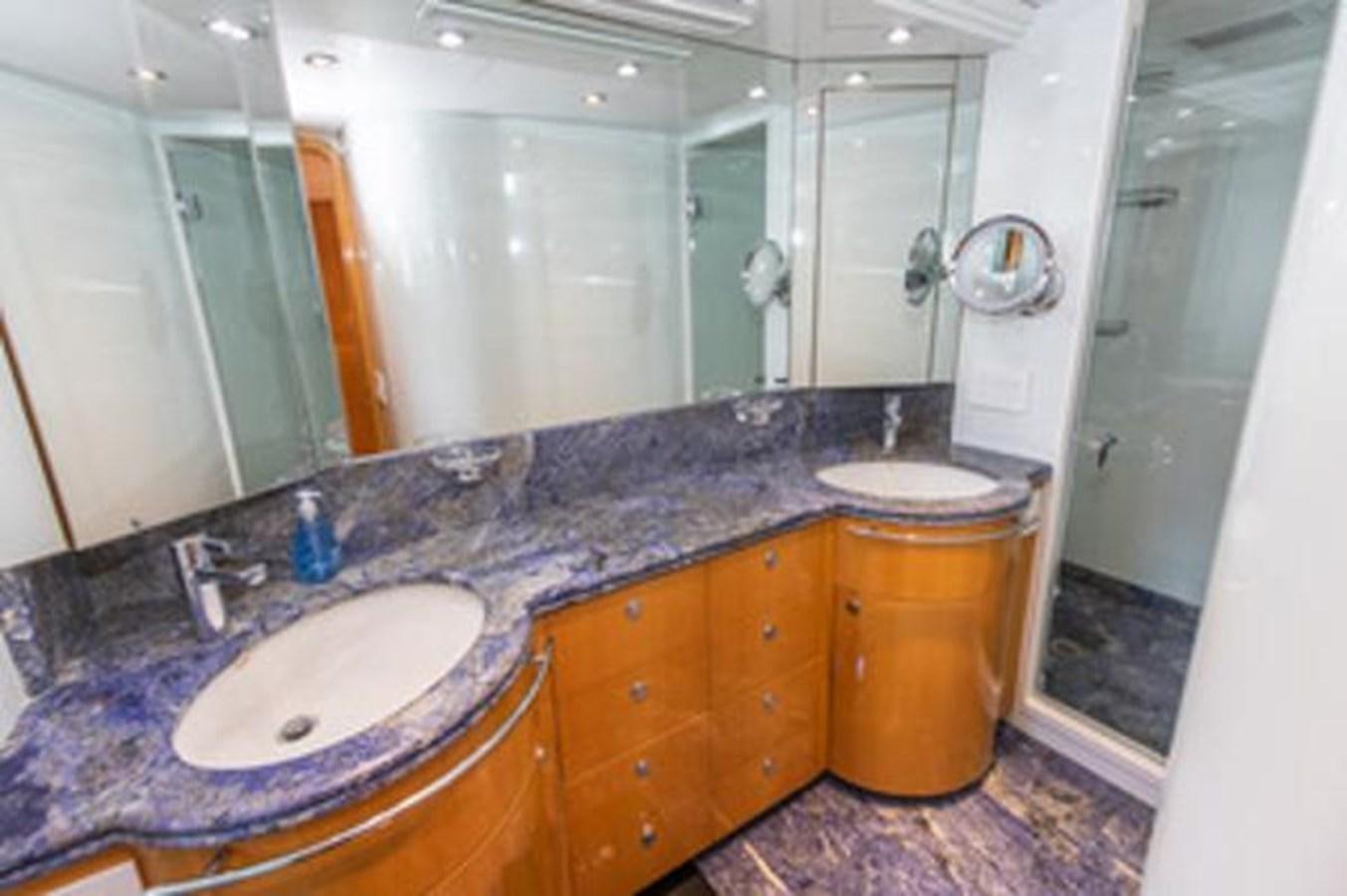 a bathroom with a countertop sink and a mirror aboard 2000 116 BAGLIETTO Yacht for Sale