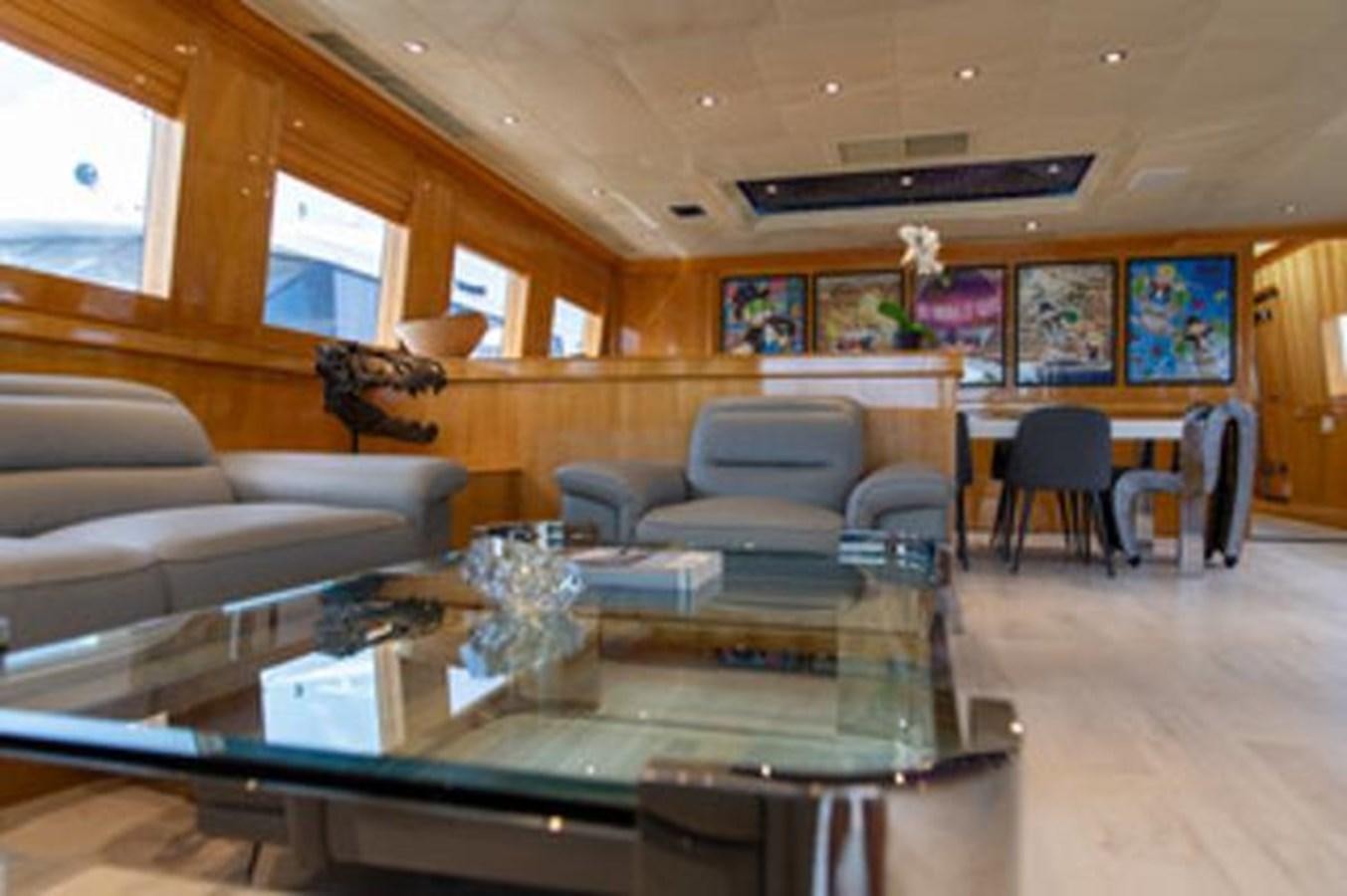 a living room with a large glass table and a couch aboard 2000 116 BAGLIETTO Yacht for Sale