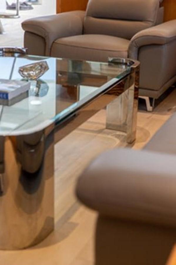 a glass coffee table in a living room aboard 2000 116 BAGLIETTO Yacht for Sale