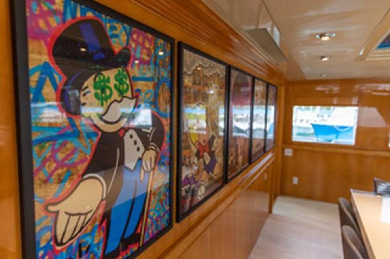 a room with paintings on the walls aboard 2000 116 BAGLIETTO Yacht for Sale