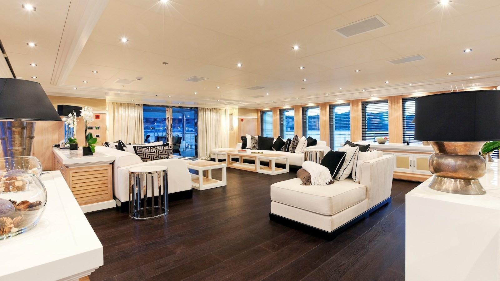 a large living room with a large black lamp and white furniture aboard BELLA 2 Yacht for Sale