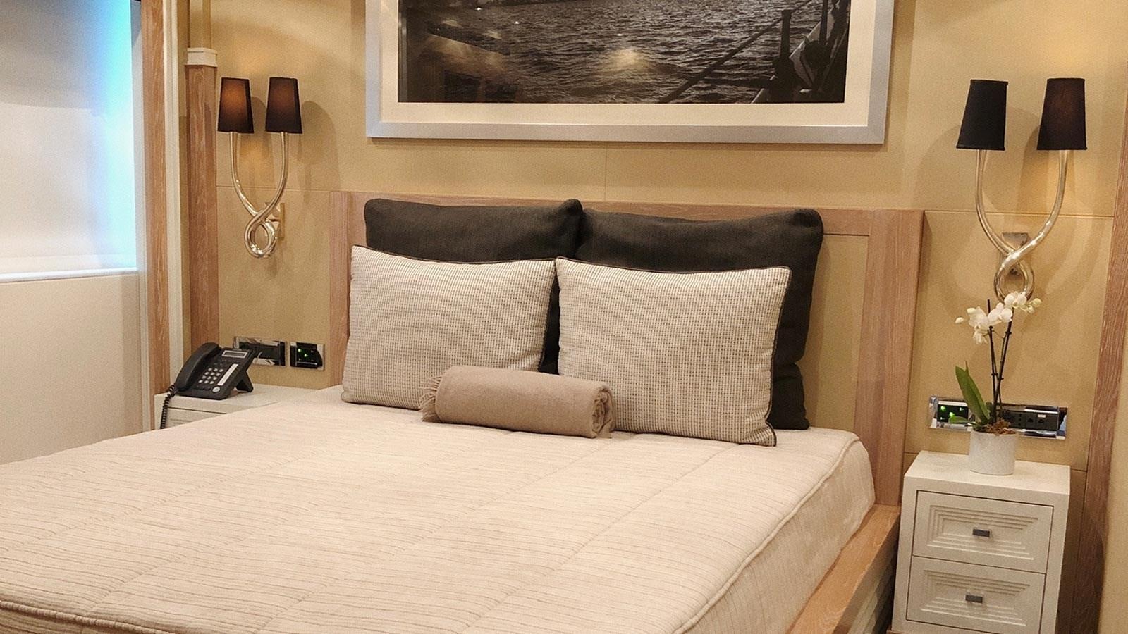 a bed with a white comforter and a black pillow aboard BELLA 2 Yacht for Sale