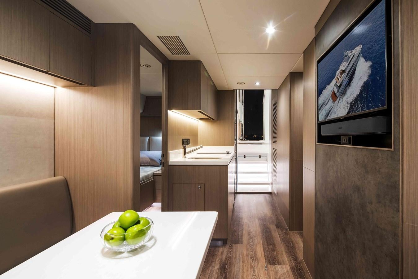 a room with a table and a tv on the wall aboard FD110-004 NEW ARRIVAL Yacht for Sale