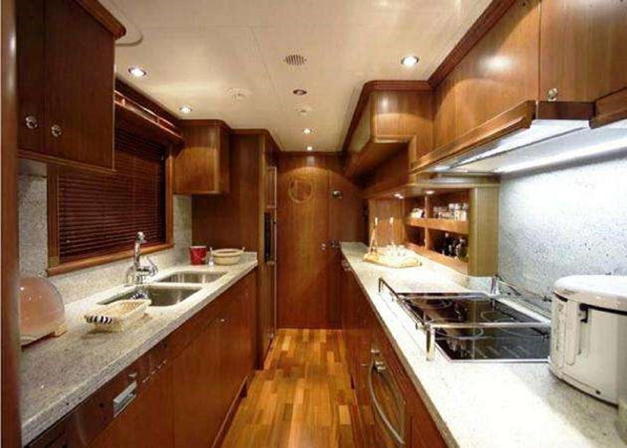 a kitchen with wooden cabinets aboard ENIGMA Yacht for Sale