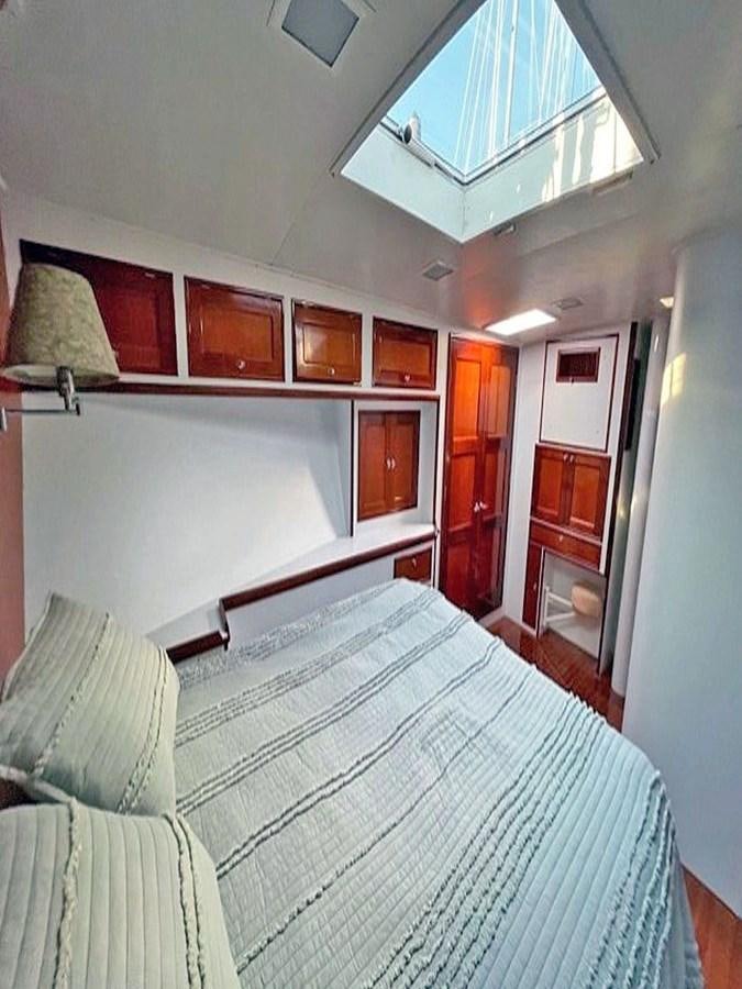 a bedroom with a bed and a lamp aboard SIROCCO Yacht for Sale
