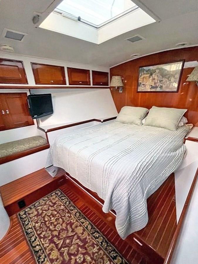 a room with a bed and a television aboard SIROCCO Yacht for Sale