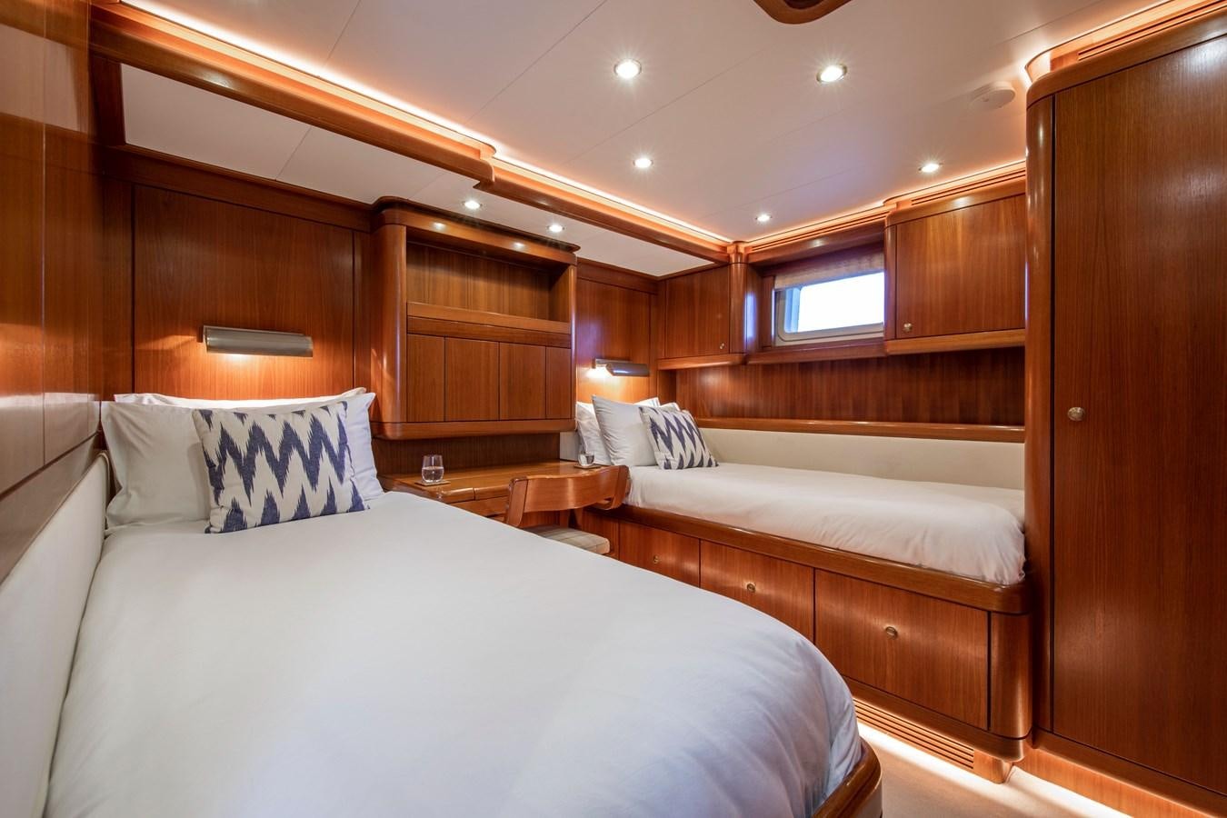 a room with a bed and a wood cabinet aboard MYSTERY Yacht for Sale