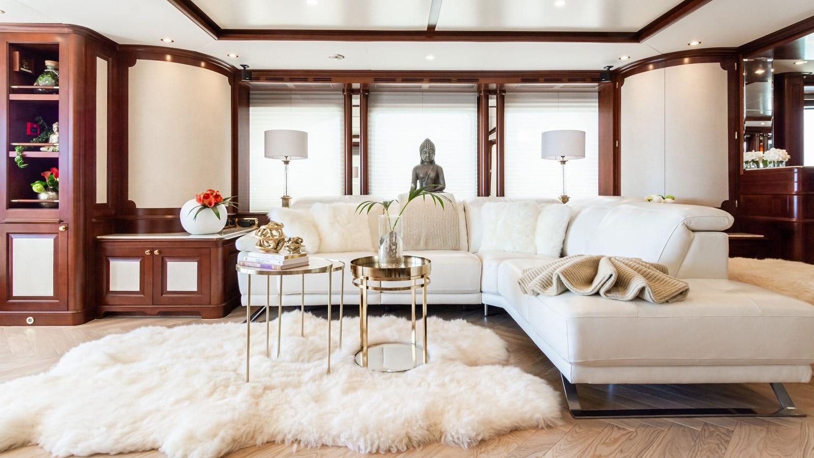 a large living room with a large white couch and a large mirror aboard GIORGIA Yacht for Sale