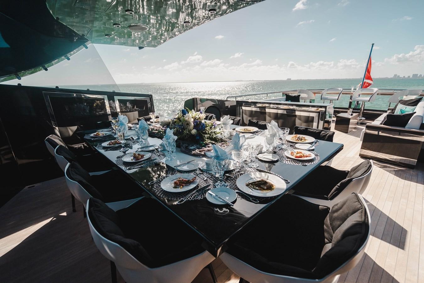 a table set with plates and flowers aboard AQUILA Yacht for Sale
