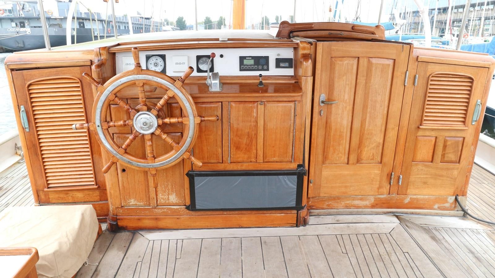 a wooden boat with a large wheel aboard ARIES Yacht for Sale