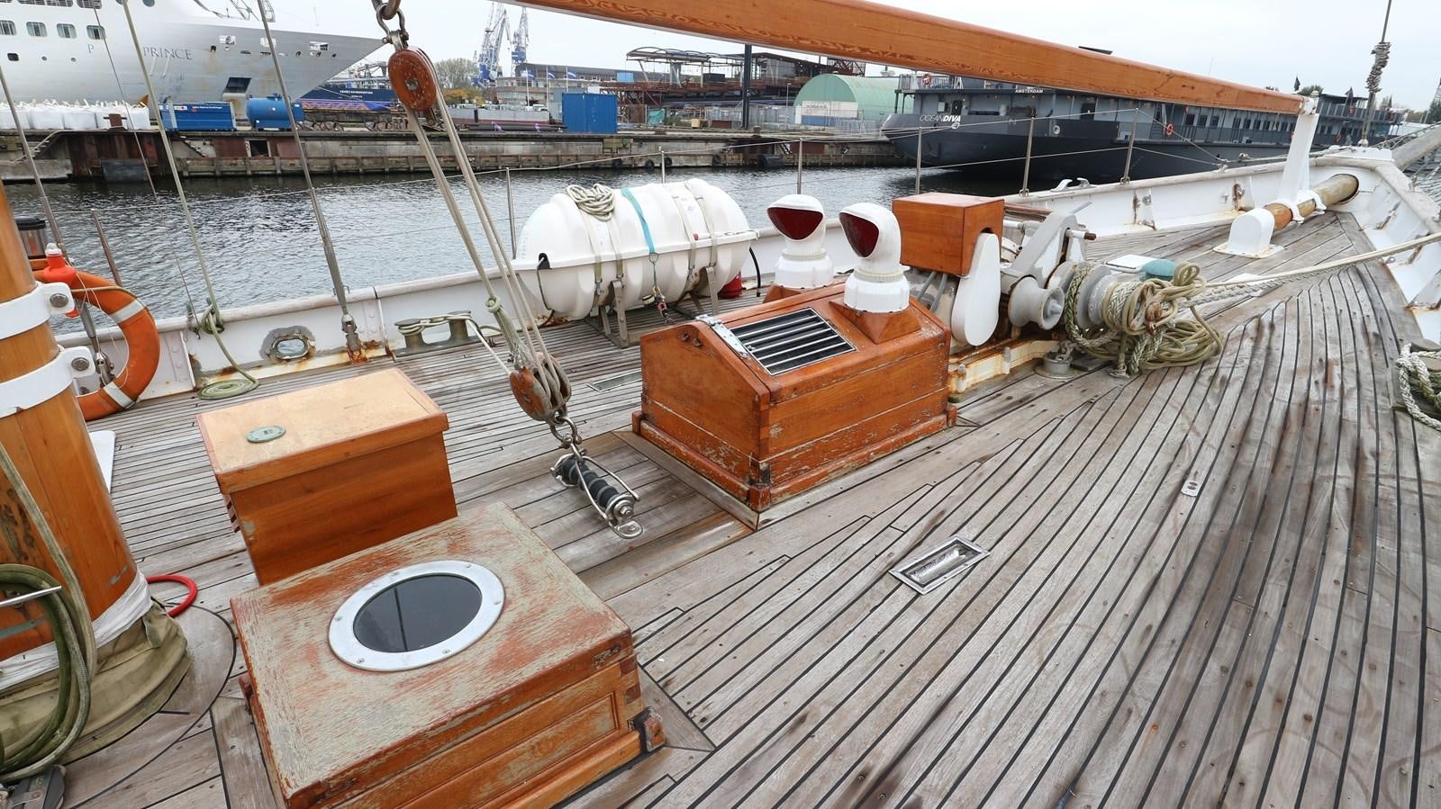 a deck with a large boat and a round table with a round white object on it aboard ARIES Yacht for Sale