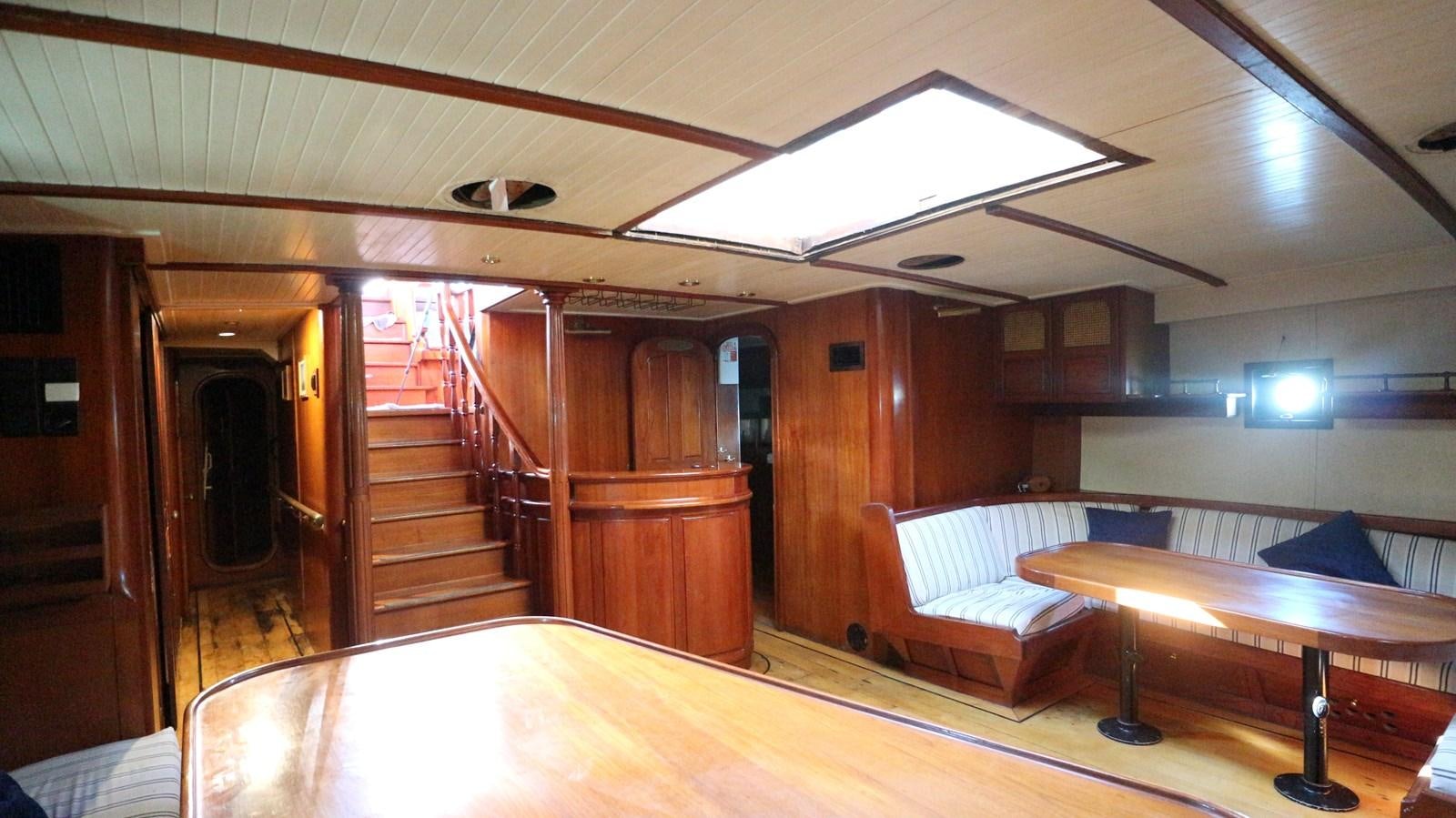 a room with a table and a couch aboard ARIES Yacht for Sale