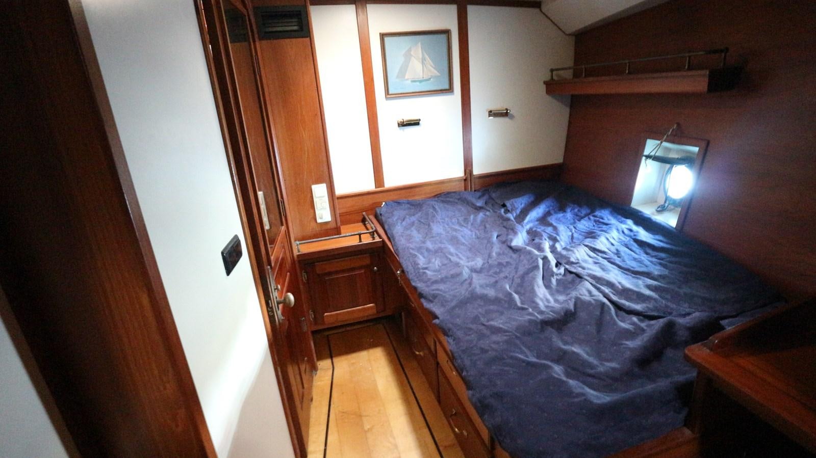 a bedroom with a bed and a lamp on the table aboard ARIES Yacht for Sale