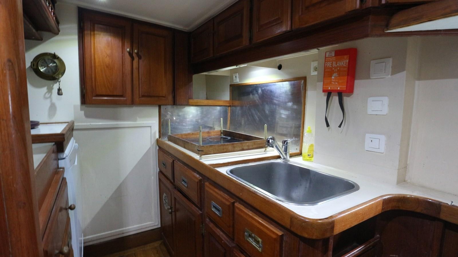 a kitchen with wooden cabinets aboard ARIES Yacht for Sale
