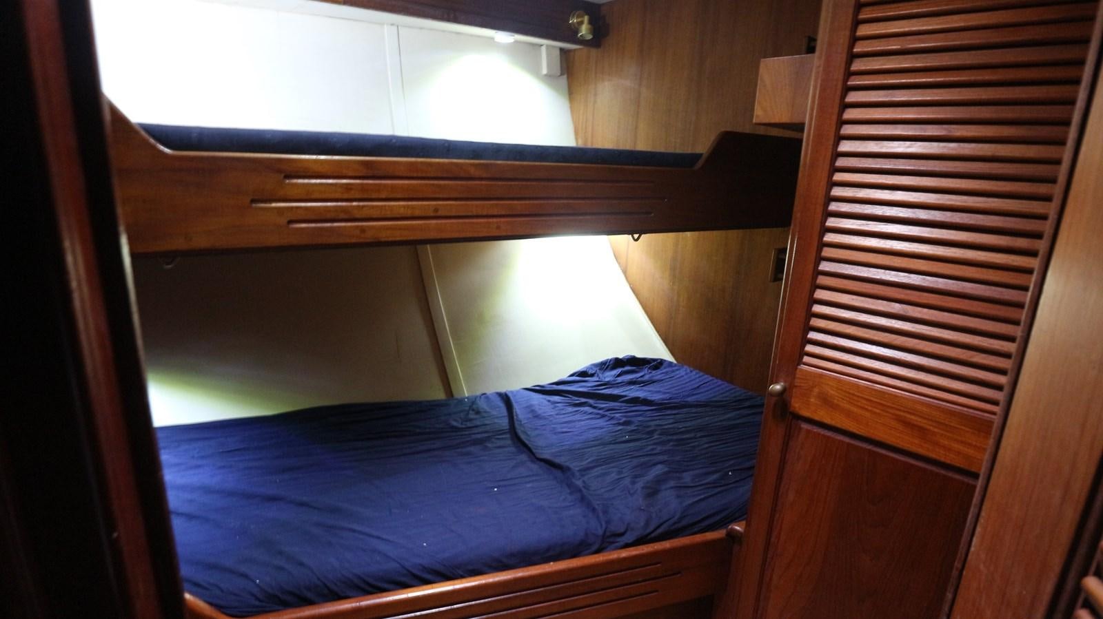 a bed with a wooden headboard aboard ARIES Yacht for Sale