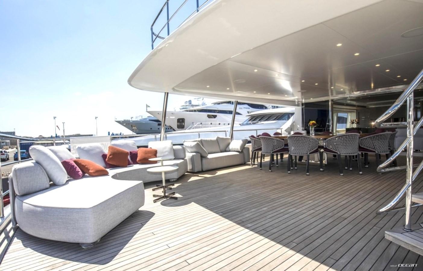 a large lounge area with a large white lounge chair and a large white yacht aboard ALEGRE Yacht for Sale