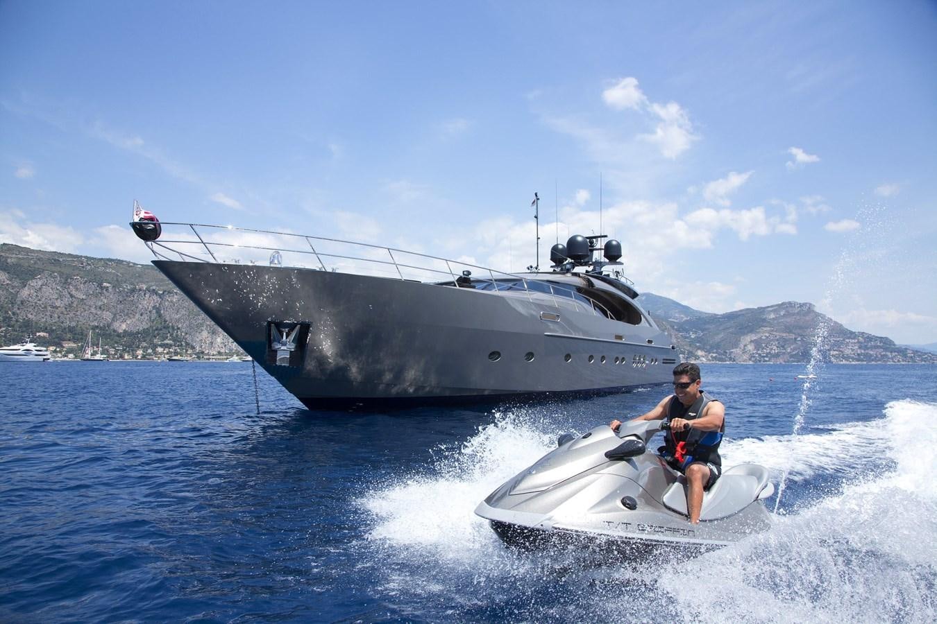 a man on a jet ski in the water next to a large ship aboard DEFIANT Yacht for Sale