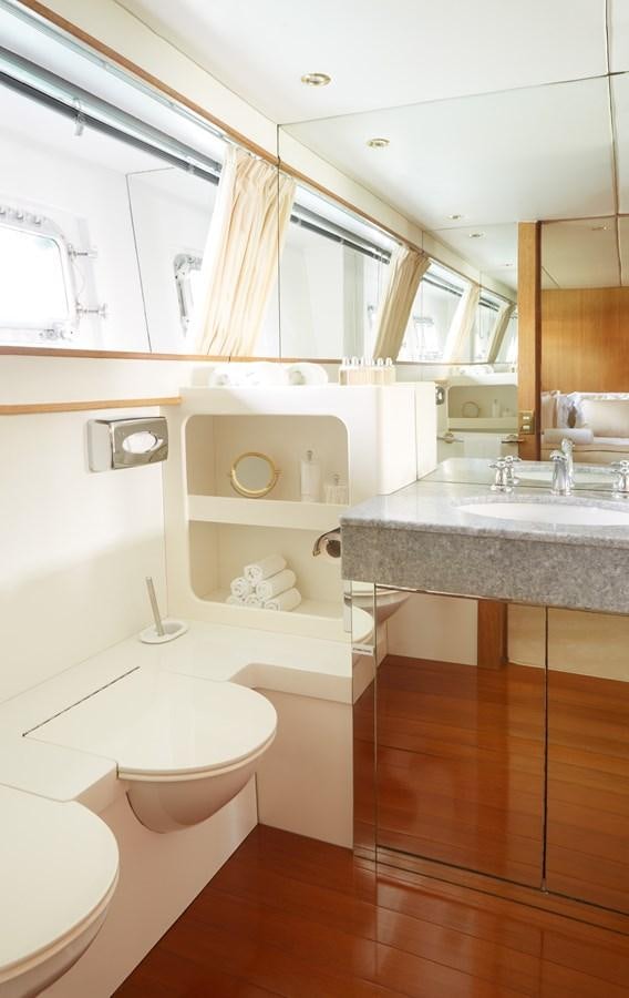 a bathroom with a sink toilet and a mirror aboard SEA LADY II Yacht for Sale