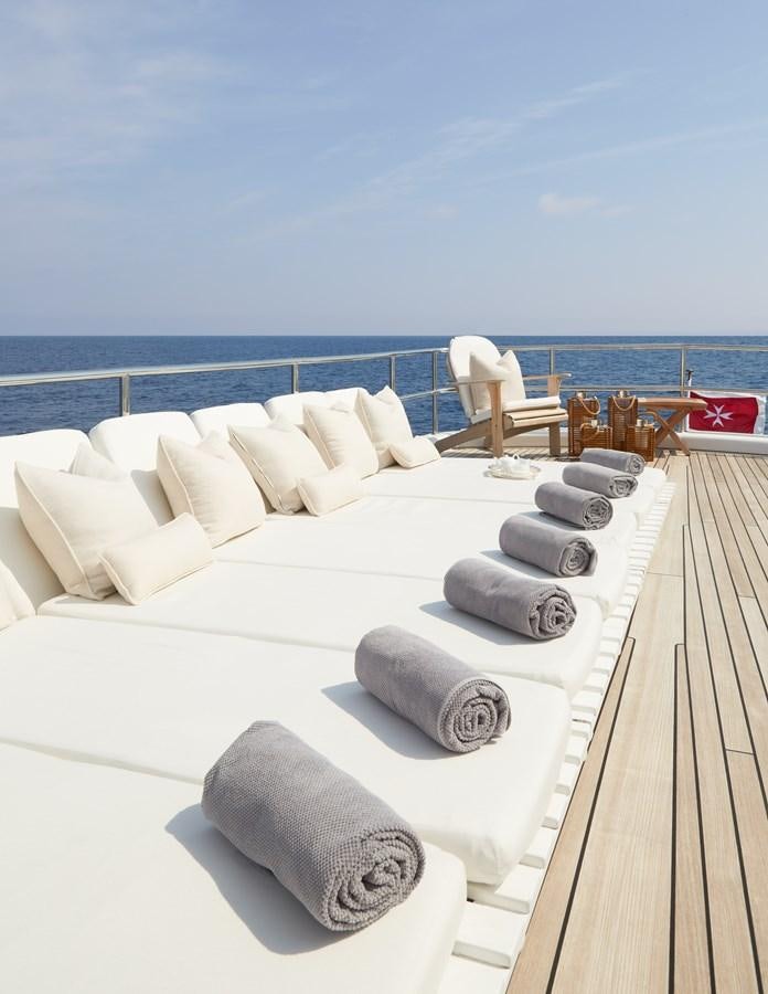 a white couch with pillows on a deck overlooking the ocean aboard SEA LADY II Yacht for Sale