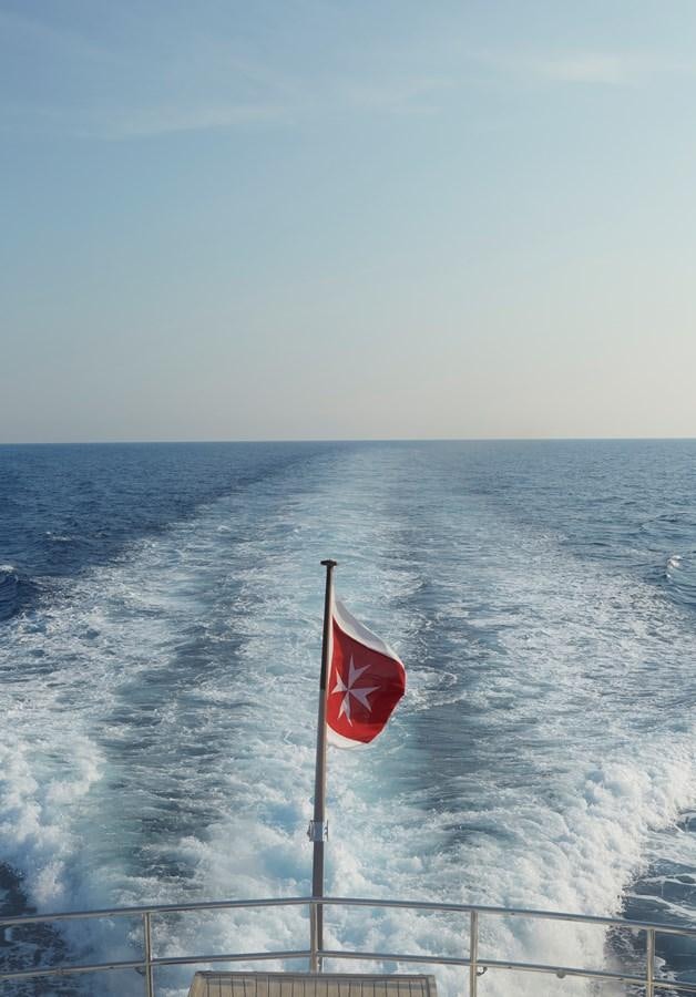 a flag on a pole above the ocean aboard SEA LADY II Yacht for Sale