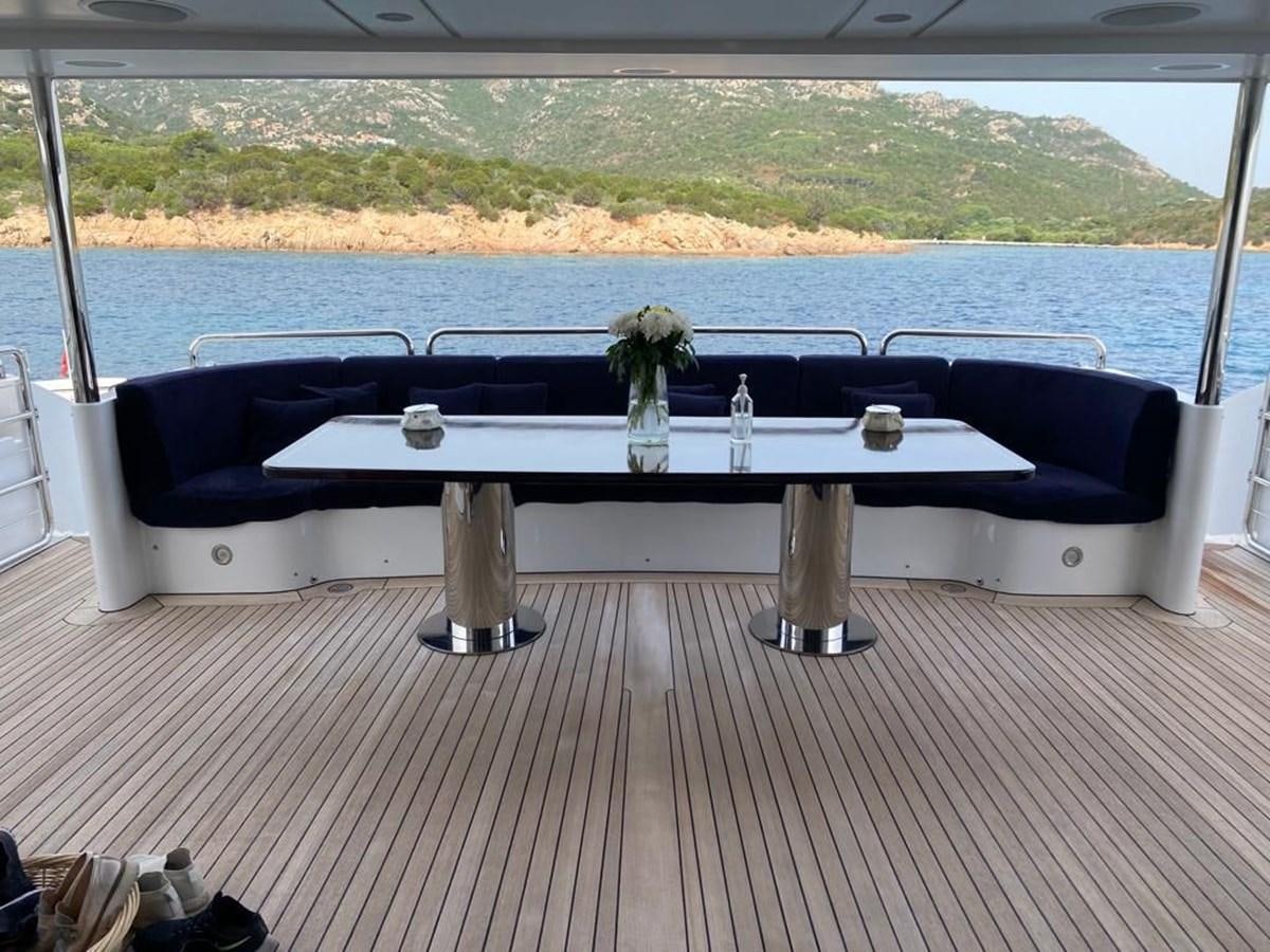 a table with a bottle and a vase on it aboard CLASSIC 121 Yacht for Sale