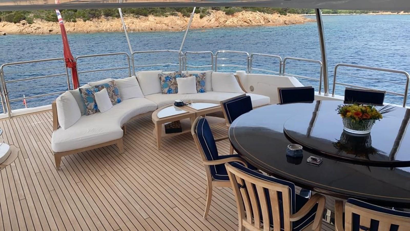 a table and chairs on a boat aboard CLASSIC 121 Yacht for Sale