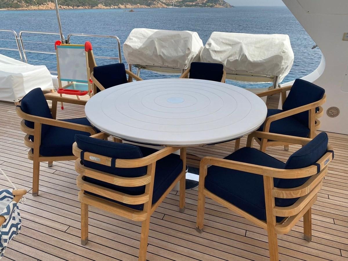 a table and chairs on a deck aboard CLASSIC 121 Yacht for Sale