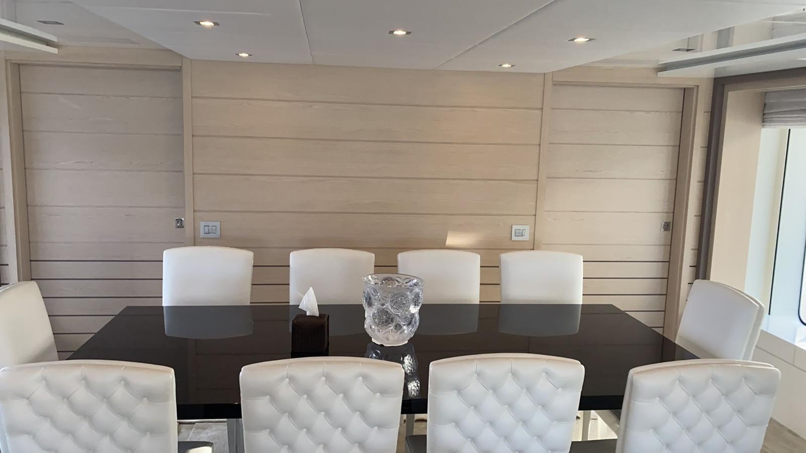 a room with chairs and a table aboard CLASSIC 121 Yacht for Sale