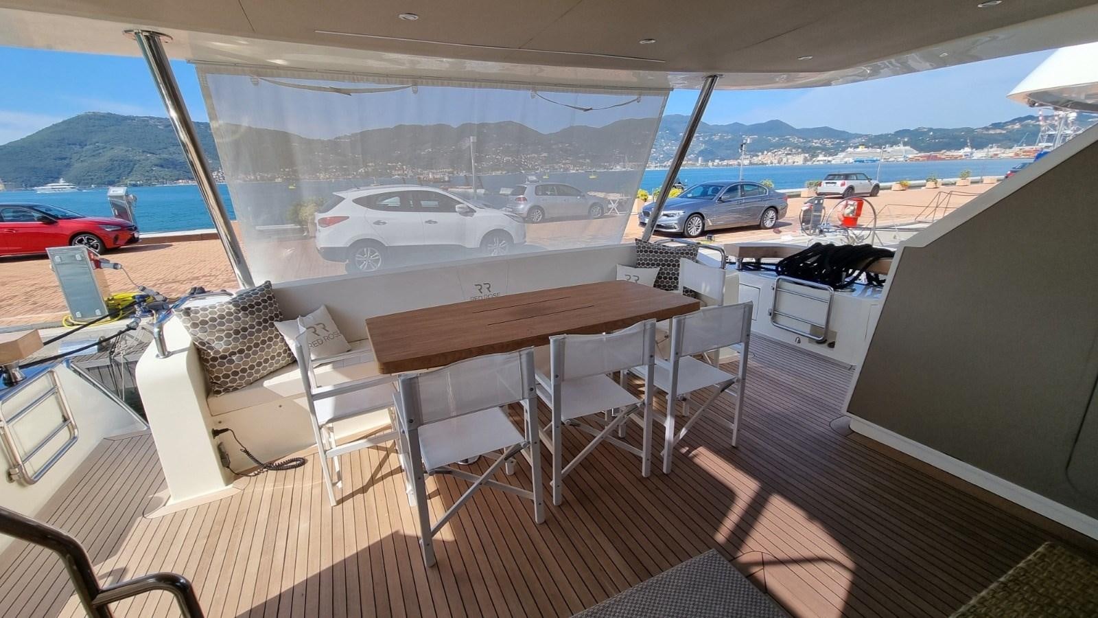 a table and chairs on a deck aboard RED ROSE Yacht for Sale