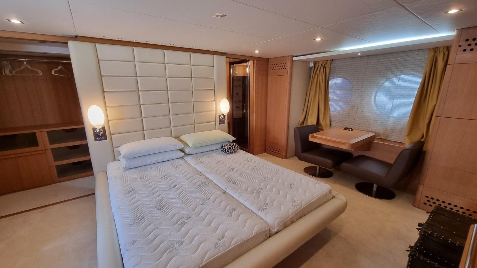 a room with a bed and a chair aboard RED ROSE Yacht for Sale