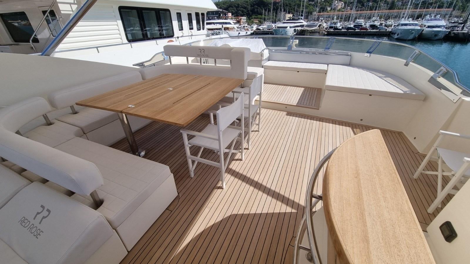 a deck with chairs and a table on it aboard RED ROSE Yacht for Sale