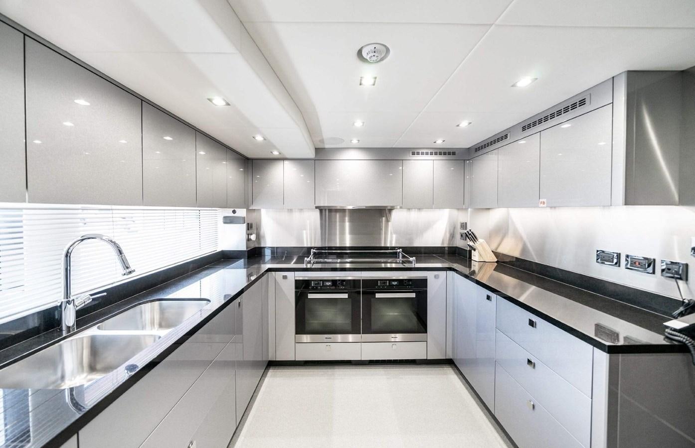 a kitchen with white cabinets aboard HKMAS Yacht for Sale