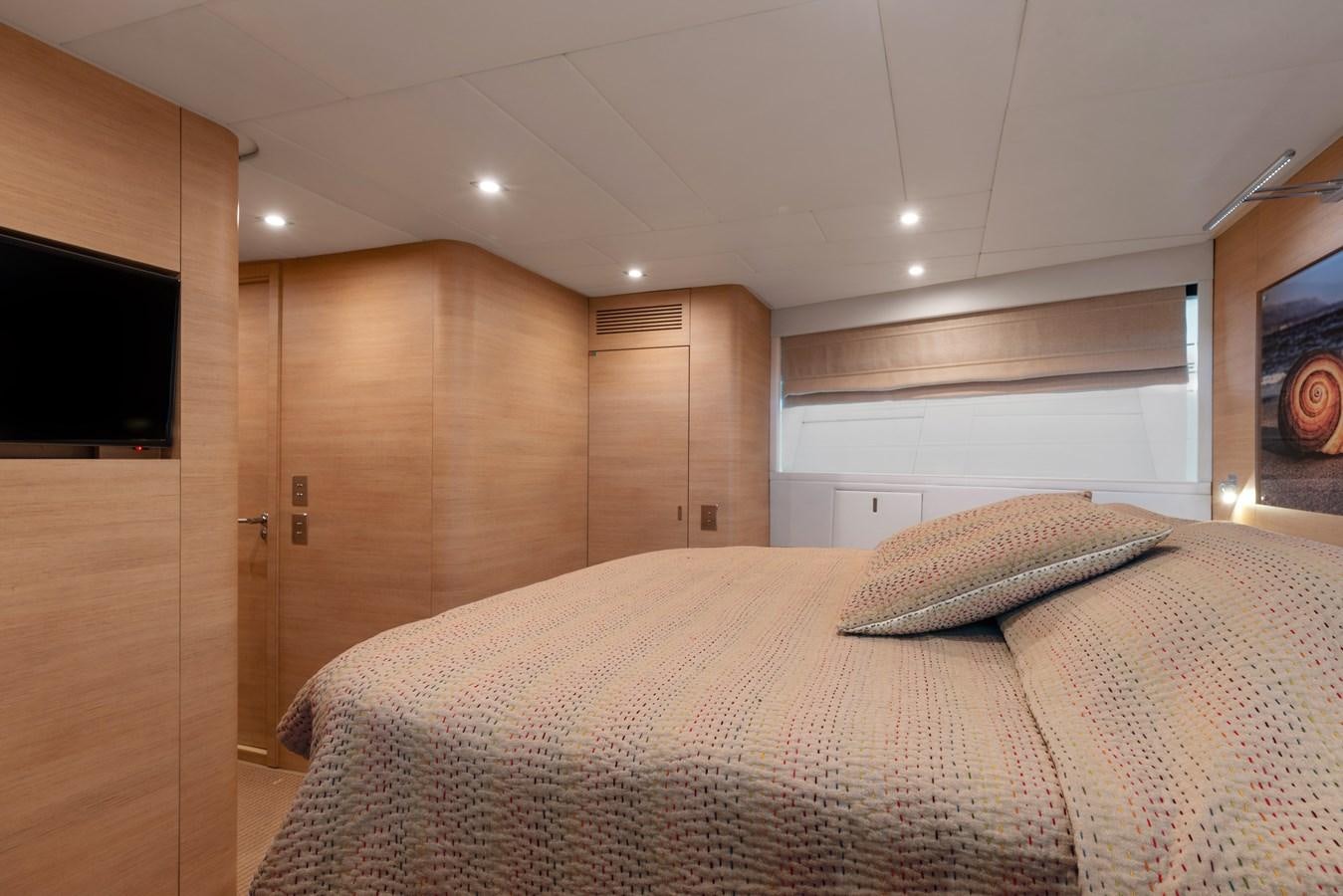 a bedroom with a bed and a wood cabinet aboard BLUE PRINCESS STAR Yacht for Sale
