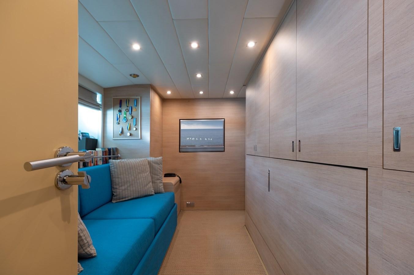 a room with a blue couch and a mirror aboard BLUE PRINCESS STAR Yacht for Sale