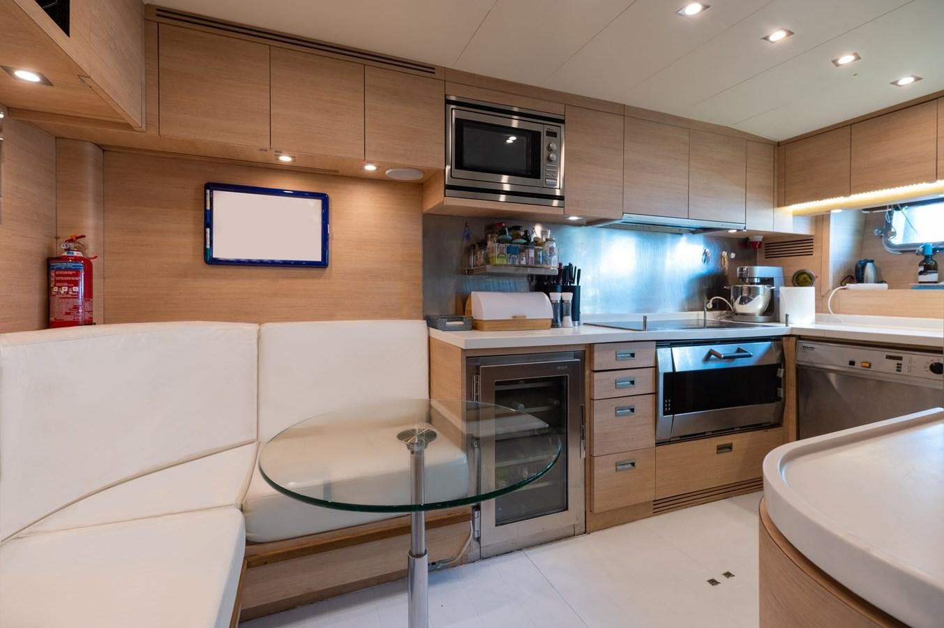 a kitchen with a white table and a black microwave aboard BLUE PRINCESS STAR Yacht for Sale