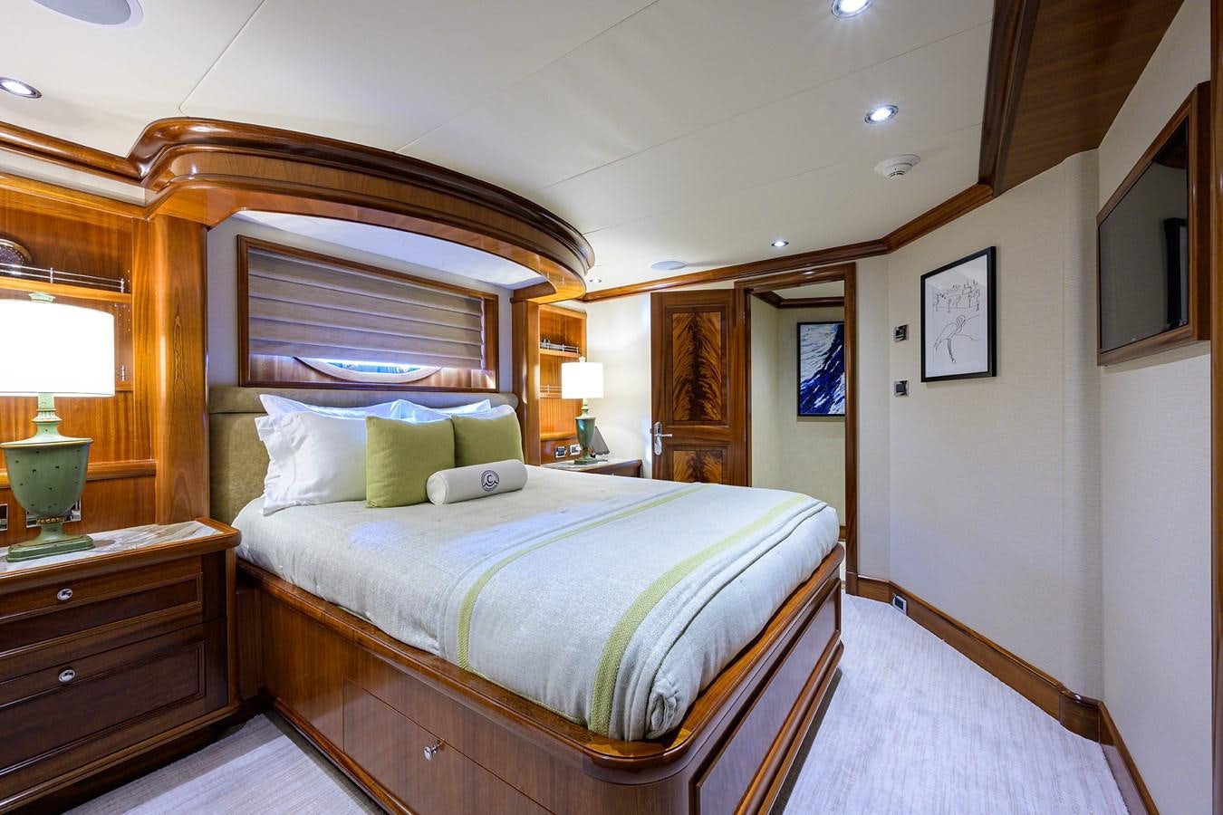 a bedroom with a bed and a lamp aboard REVIVE Yacht for Sale