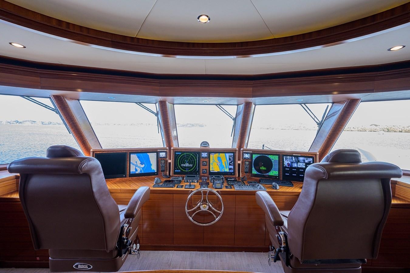 inside of a vehicle with seats and a steering wheel and a view of the ground through the window aboard REVIVE Yacht for Sale