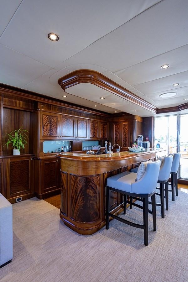a kitchen with a bar and a table aboard REVIVE Yacht for Sale