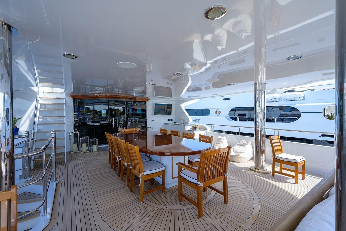 a large room with a table and chairs and a large boat in the background aboard REVIVE Yacht for Sale