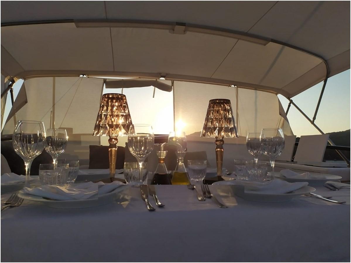 a table with wine glasses and plates aboard P Yacht for Sale