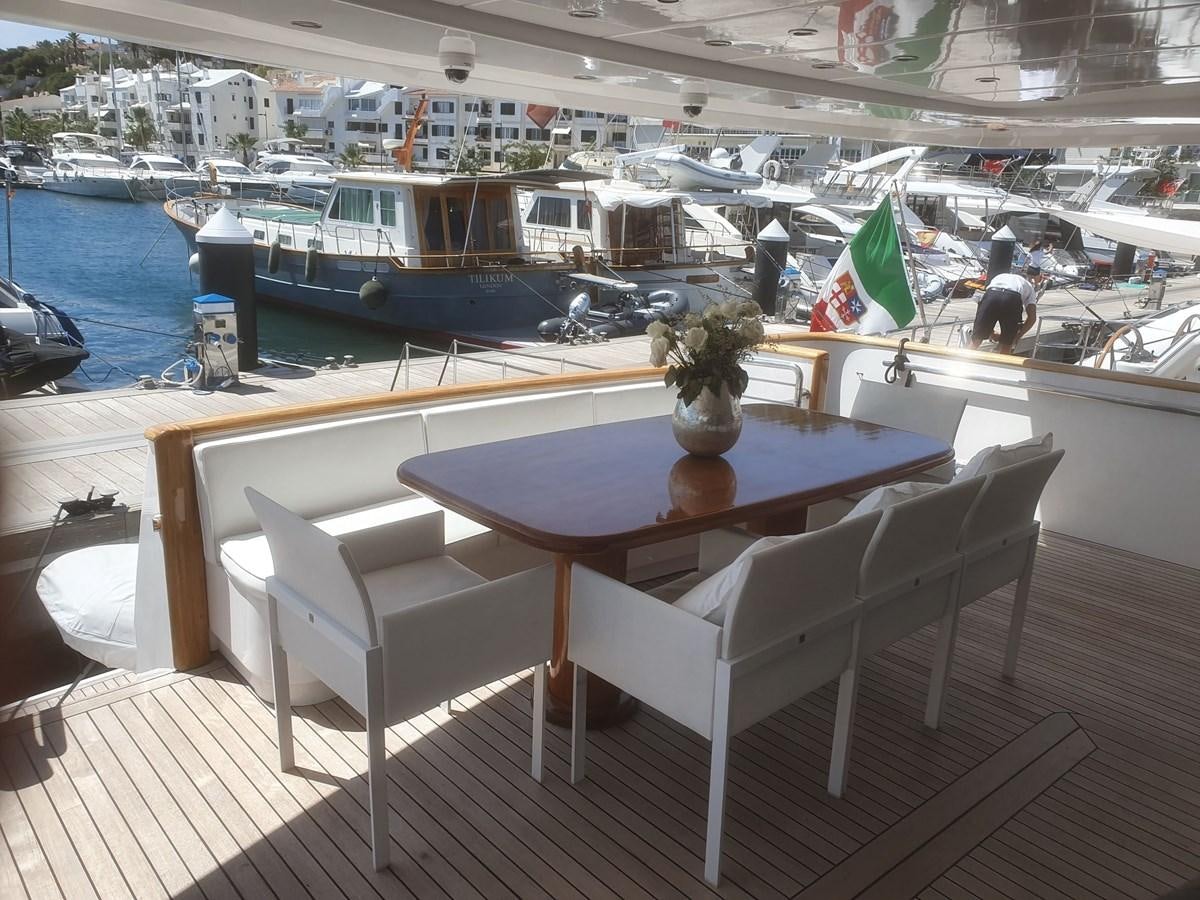 a table and chairs on a deck aboard P Yacht for Sale