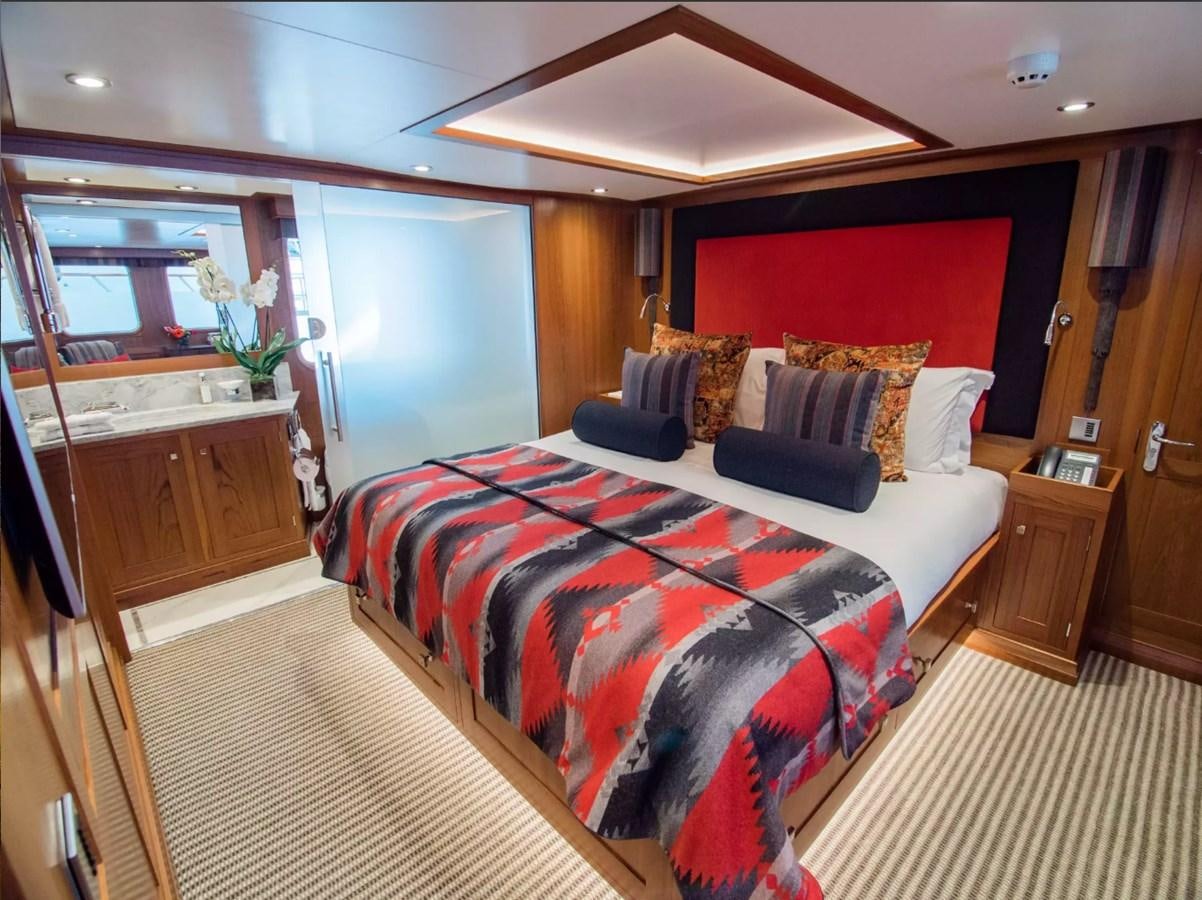 a bedroom with a bed and a desk aboard CHARISMA Yacht for Sale