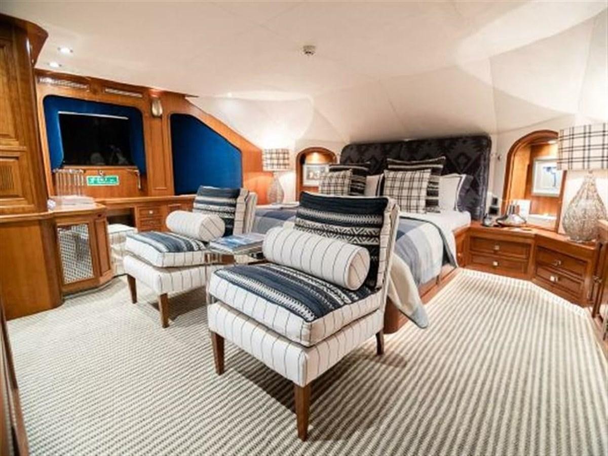 a bedroom with a bed and a chair aboard CHARISMA Yacht for Sale